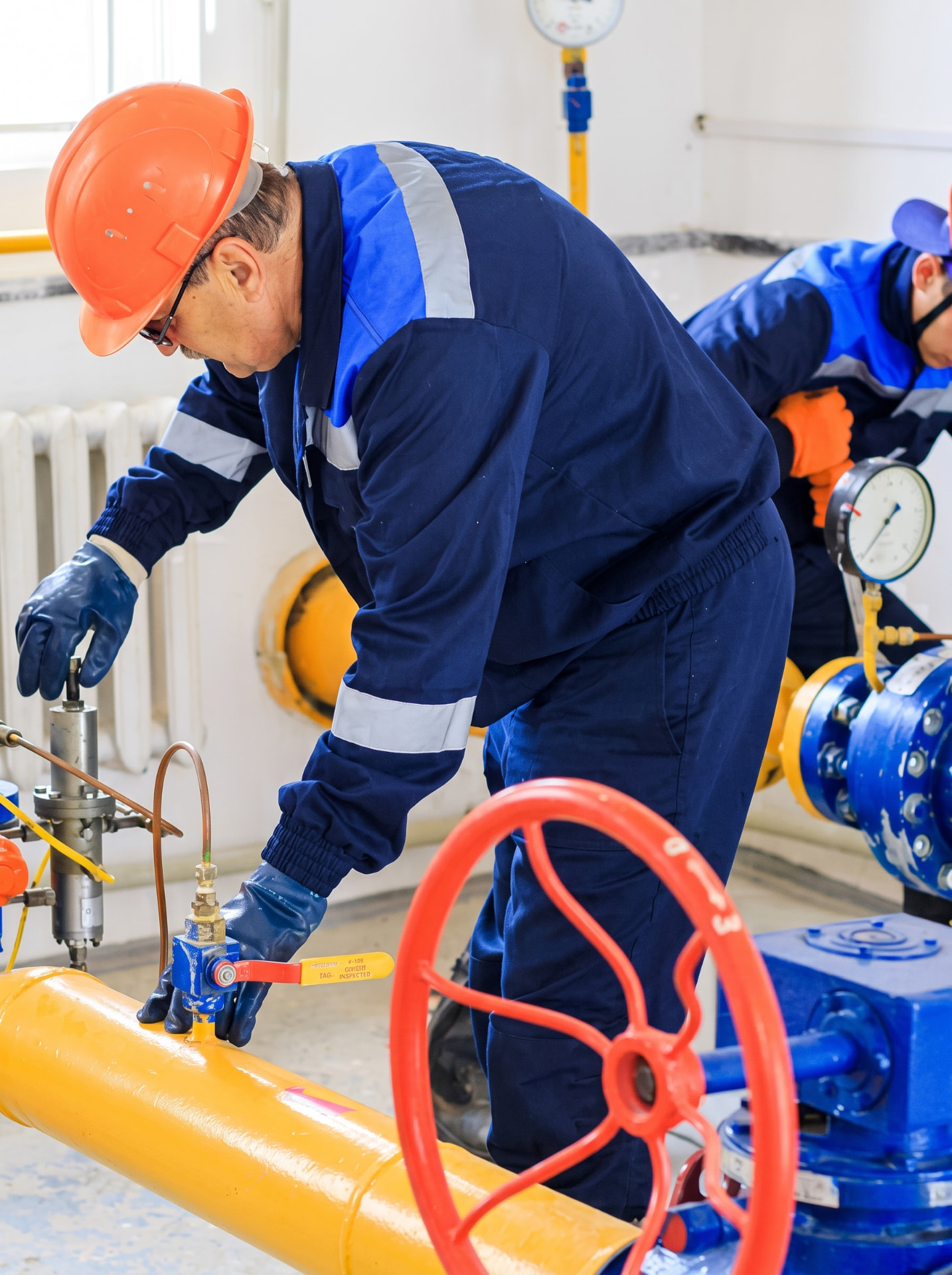 Equipe trabalhando em tubulações e válvulas industriais